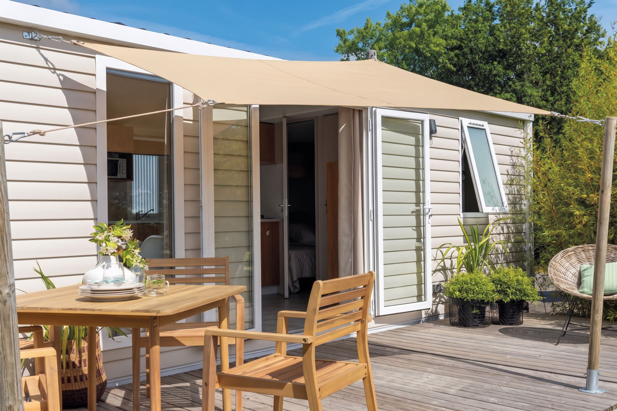 Voile d’ombrage tendue au-dessus d’une terrasse de mobil-home